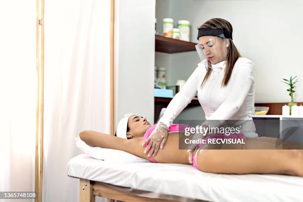 woman receiving a back massage in a therapy office - parte del cuerpo humano stock pictures, royalty-free photos & images