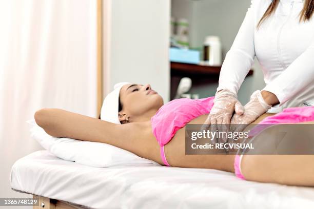 woman receiving a back massage in a therapy office - parte del cuerpo humano stock pictures, royalty-free photos & images