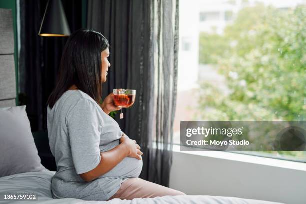 shot of a young lady drinking tea while sitting in a bedroom - ice tea stock pictures, royalty-free photos & images