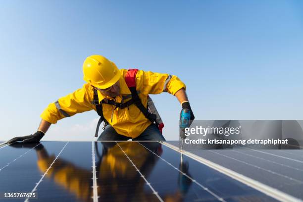 solar panel technician with drill installing solar panels on roof,electrician panel sun sustainable resources renewable energy source alternative innovation. - solkraftverk bildbanksfoton och bilder