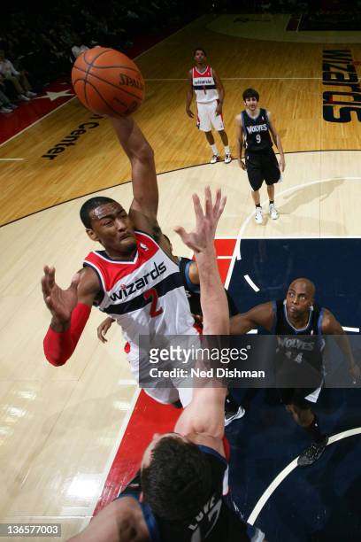 John Wall of the Washington Wizards dunks against Kevin Love of the Minnesota Timberwolves during the game at the Verizon Center on January 8, 2012...