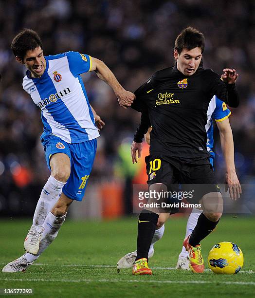 Lionel Messi of FC Barcelona duels for the ball with Juan Forlin of RCD Espanyol during the La Liga match between RCD Espanyol and FC Barcelona at...