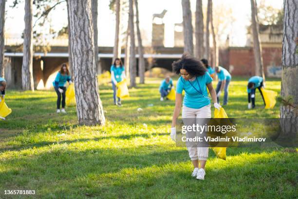 group of people collecting rubbish from the parkland - garbage man stock pictures, royalty-free photos & images