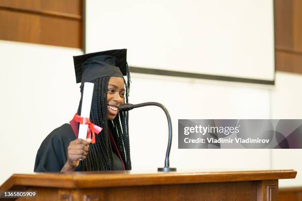 a female graduate having a ceremony speech in the university lecture hall - graduation speech stock pictures, royalty-free photos & images