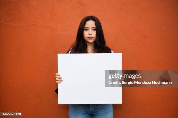 young latino woman holding a blank sign - blank sign stock pictures, royalty-free photos & images