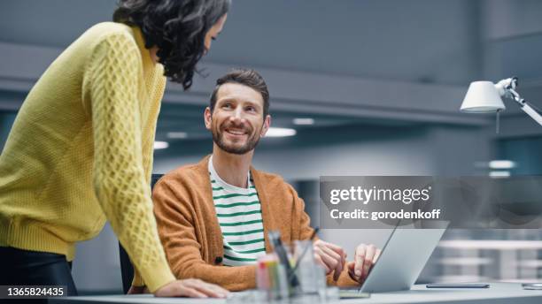 Modern Office: Business Meeting of Two Businesspeople Talking at the Desk. Businessman and Businesswoman Work on Strategy, Brainstorm for e-Commerce Software Design. Shot with Motion Blur Background