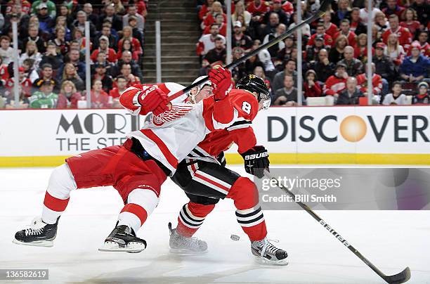 Danny Cleary of the Detroit Red Wings and Nick Leddy of the Chicago Blackhawks battle for the puck during the NHL game on January 8, 2012 at the...