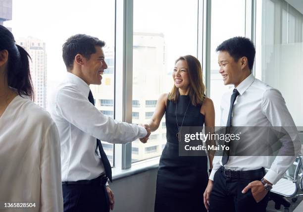 young chinese executives discussing work during a break in meetings - ビジネスフォーマル ストックフォトと画像