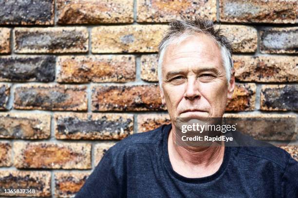 mature man stares grimly directly at the camera, looking serious and displeased - squinting stock pictures, royalty-free photos & images