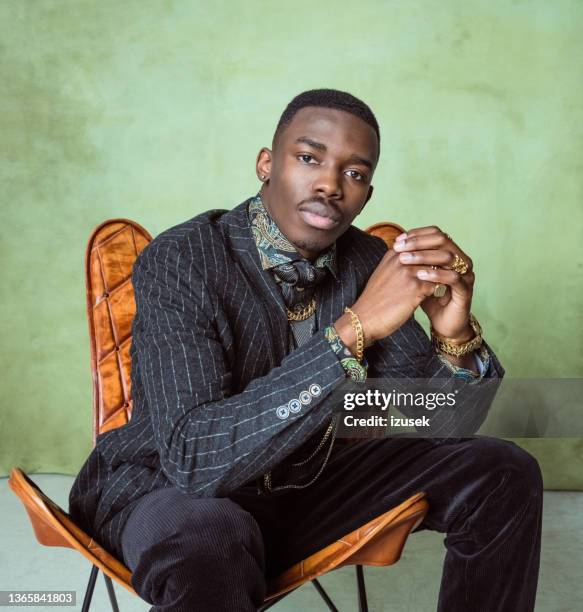 glamour portrait of elegant young man - luxury model pose with chair stockfoto's en -beelden