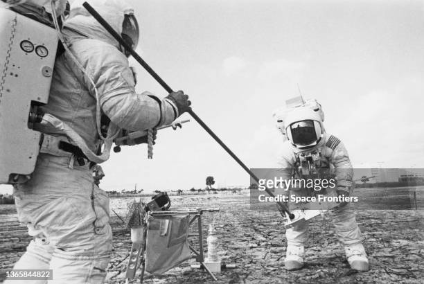 American NASA astronaut Fred Haise and American NASA astronaut Jim Lovell adjust a portion of the heat flow experiment, containing a drill to...