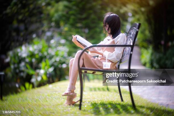 relax on the park - mujer leyendo libro en el parque fotografías e imágenes de stock