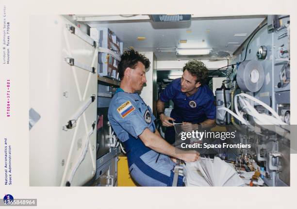 British-American NASA astronaut Michael Foale and American NASA astronaut Jerry M Linenger conduct transfer ops in the Mir Space Station Priroda...