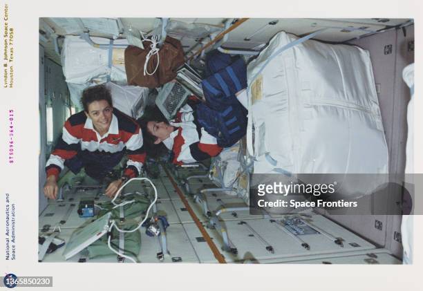 American NASA astronaut Ellen Ochoa reviews a checklist while Canadian CSA astronaut Julie Payette works with the stowage bags in the FGB/Zarya...