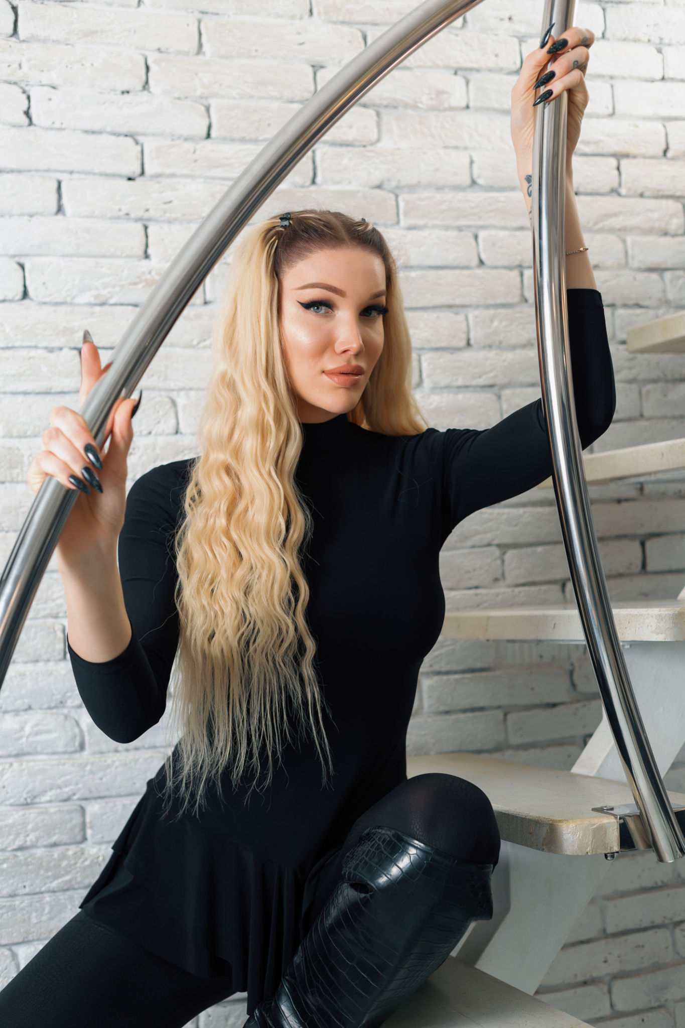 Beautiful blondie sitting on stairs and posing at camera Beautiful blondie sitting on stairs and posing at camera