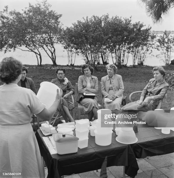 Group of women enjoy a Tupperware Home Parties event in their back garden, USA, circa 1955.