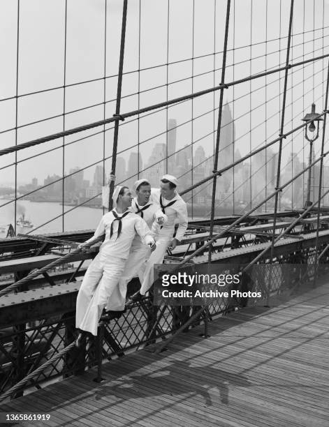 From left to right, actors Jules Munshin, Frank Sinatra and Gene Kelly dressed as sailors on Brooklyn Bridge in New York City, USA, to publicise the...