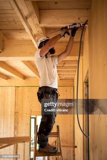 construction worker applying glue with silicone gun - silicon stock pictures, royalty-free photos & images