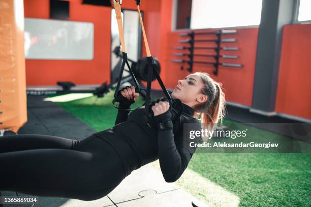 female athlete developing arm strength with pullup exercise in gym - doing pull ups stock pictures, royalty-free photos & images