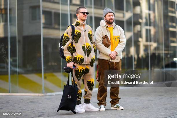 Guest wears a gray ribbed beanie, a white t-shirt, a yellow pullover, a half sheep and half yellow zipper coat from Patagonia, a brown Carhartt...