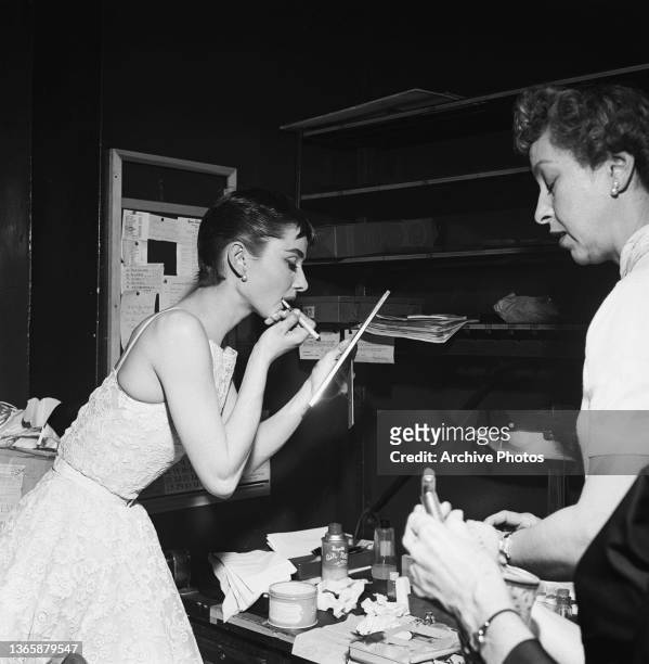 Actress Audrey Hepburn touches up her lipliner backstage at the 26th Academy Awards at the NBC Century Theatre in New York City, USA, 25th March...