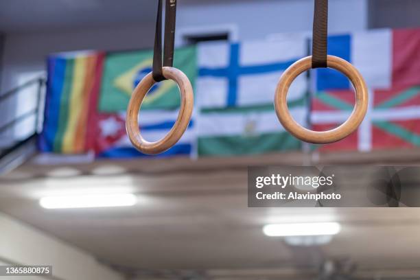 rings hanging on a gym crosstraining box with country flags behind - the ring of steel stock pictures, royalty-free photos & images