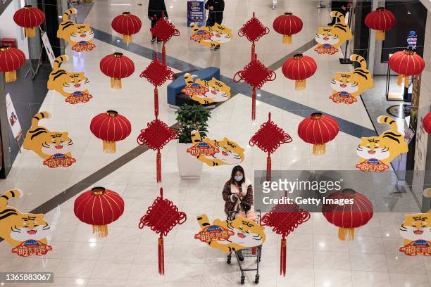 People walk past the lanterns and cartoon tiger decorations in a shopping mall on January 20, 2022 in Wuhan, Hubei Province, China. Life for many of...