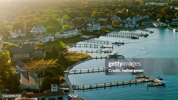 casas y embarcaderos en el puerto de hyannis en cape cod al atardecer - aéreo - hyannis port fotografías e imágenes de stock