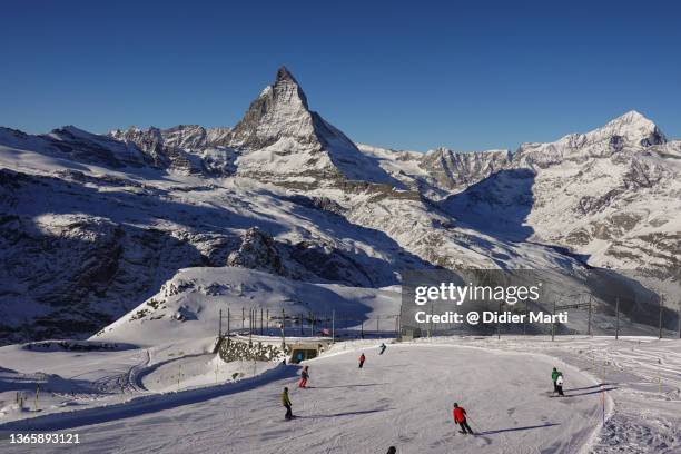 skiers on the slope of the famous zermatt ski resort with the matterhorn peak, switzerland - zermatt stock pictures, royalty-free photos & images