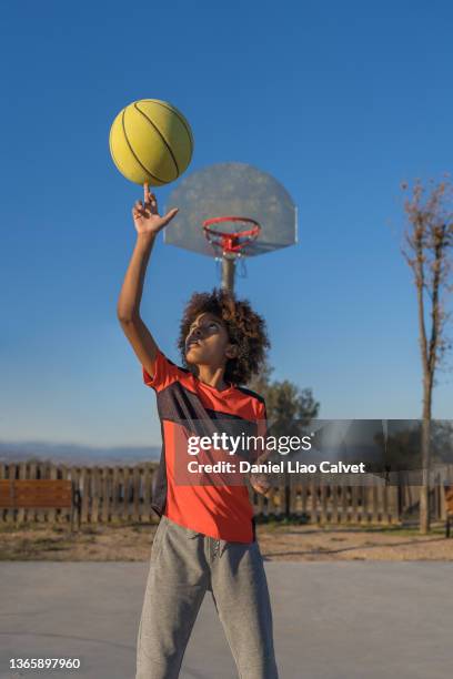 african american basketball player boy spinning ball on finger - drive ball sports fotografías e imágenes de stock