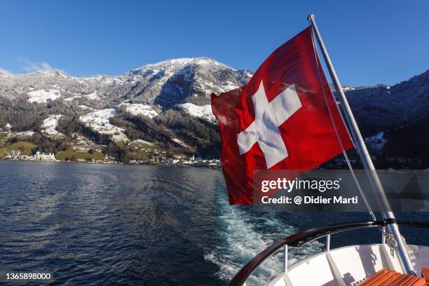 swiss flag at the back on a boat sailing on lake lucerne in switzerland - swiss flag stockfoto's en -beelden