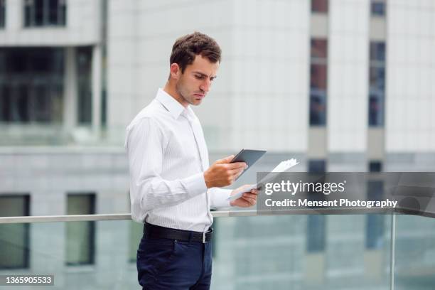 smart young manager in the city using a digital tablet - man suit using phone tablet foto e immagini stock