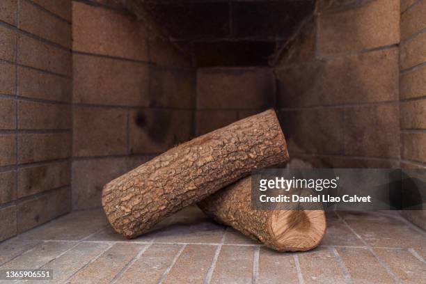 close-up of two unburned wood logs in the fireplace - log stock-fotos und bilder