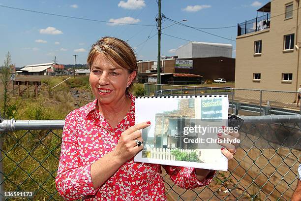 Queensland Premier Anna Bligh holds a photograph showing the damage of the floods on January 9, 2012 in Toowoomba. January marks one year since...