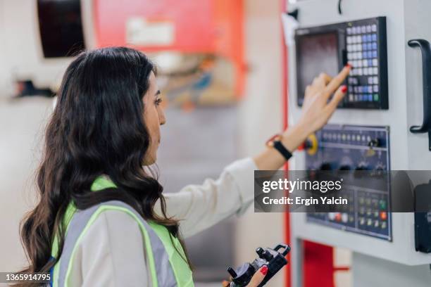 female operator programming a cnc machine3 - cnc stock pictures, royalty-free photos & images