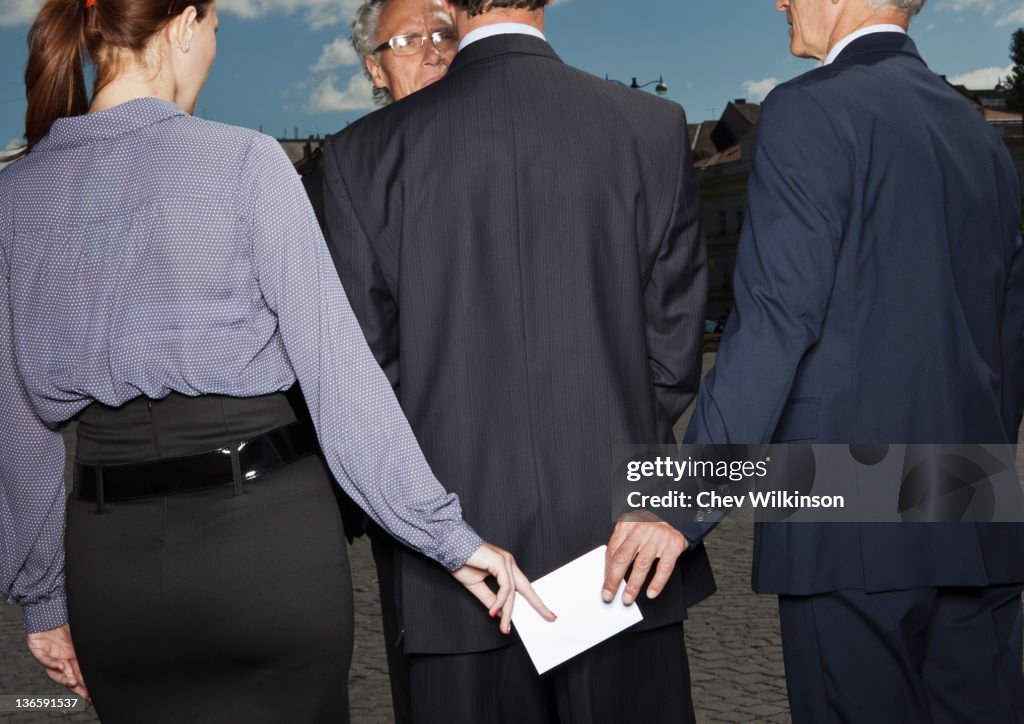 Business people secretly passing notes