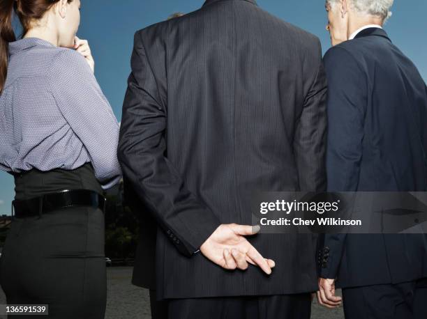 businessman secretly crossing fingers - fingers crossed stock pictures, royalty-free photos & images