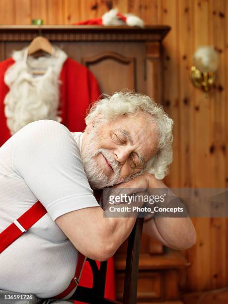 man with santa claus suit napping - santa leaning stock pictures, royalty-free photos & images
