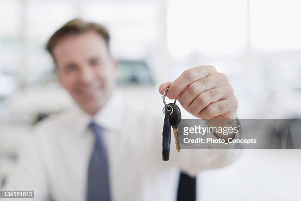 close up of car salesman holding keys - salesman stock pictures, royalty-free photos & images