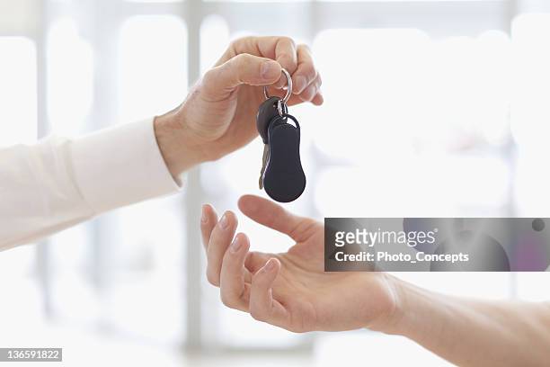 vendedor de coches entregar las llaves del cliente - dar fotografías e imágenes de stock