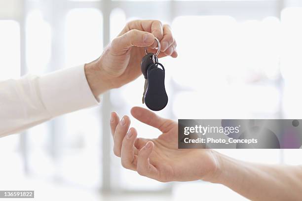 car salesman handing keys to customer - offer stock pictures, royalty-free photos & images