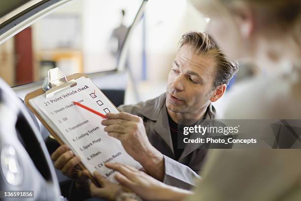 mechaniker zeigen checkliste für den kunden - auto mechaniker stock-fotos und bilder