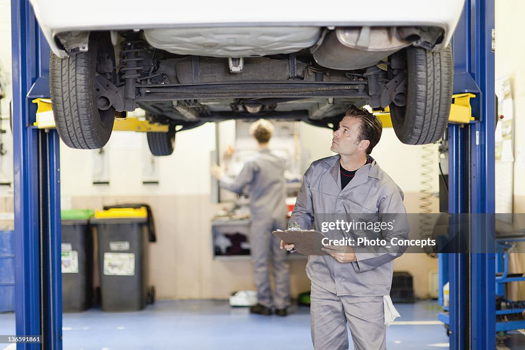 Mechaniker Prüfung der Unterseite des Autos