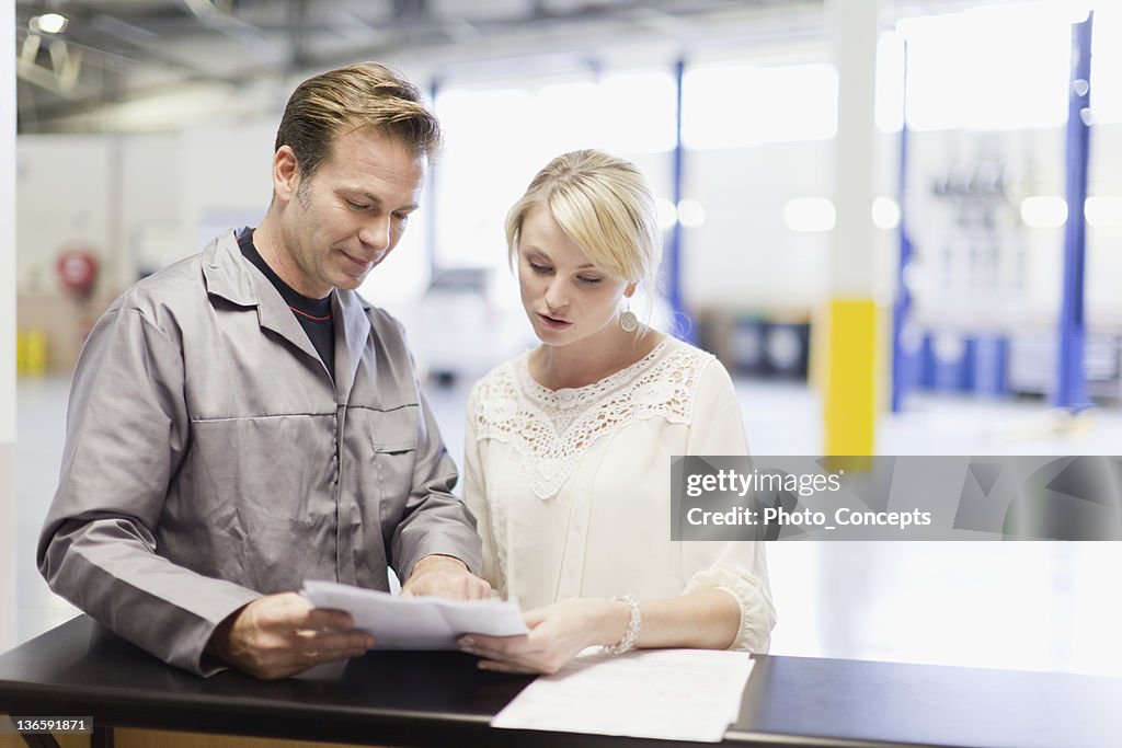 Mechanic talking to customer in garage