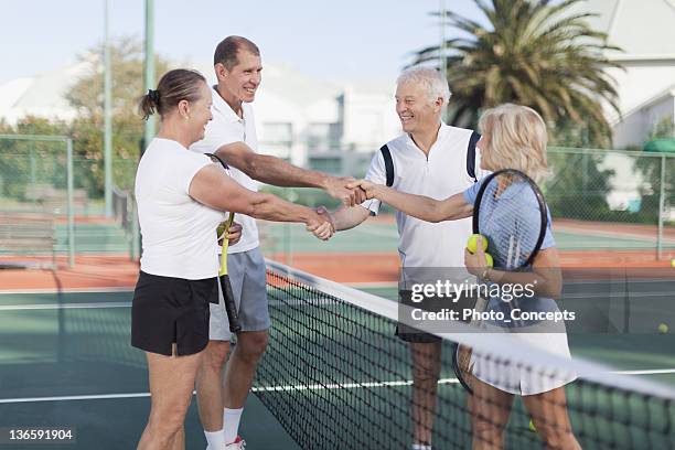 older couples shaking hands at tennis - doubles sports stock pictures, royalty-free photos & images