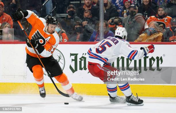 Kevin Hayes of the Philadelphia Flyers skates the puck against Braden Schneider of the New York Rangers at the Wells Fargo Center on January 15, 2022...