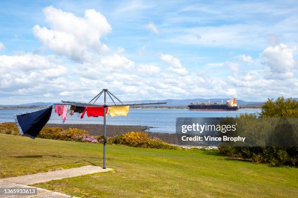 washing line by a river with clothing on it and a ship in the background - washing line stock pictures, royalty-free photos & images