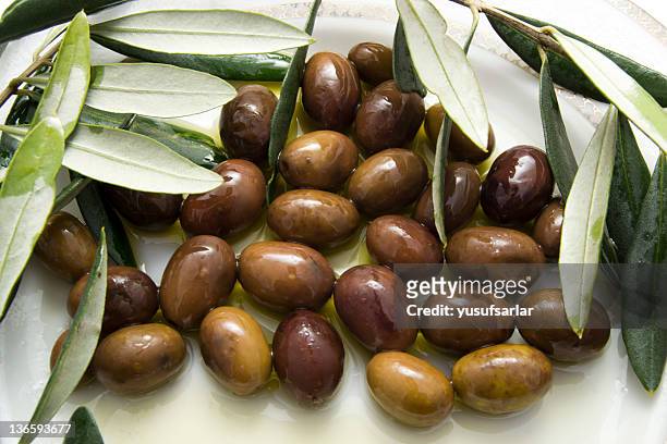 schwarze oliven mit olivenöl - kalamata olive stock-fotos und bilder