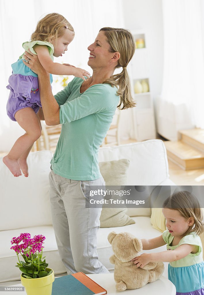 Mother playing with daughters (2-3) in living room