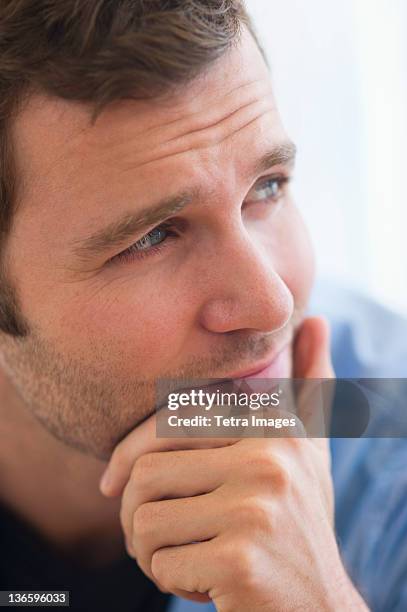 usa, new jersey, jersey city, portrait of young man with hand on chin - mano sul mento foto e immagini stock